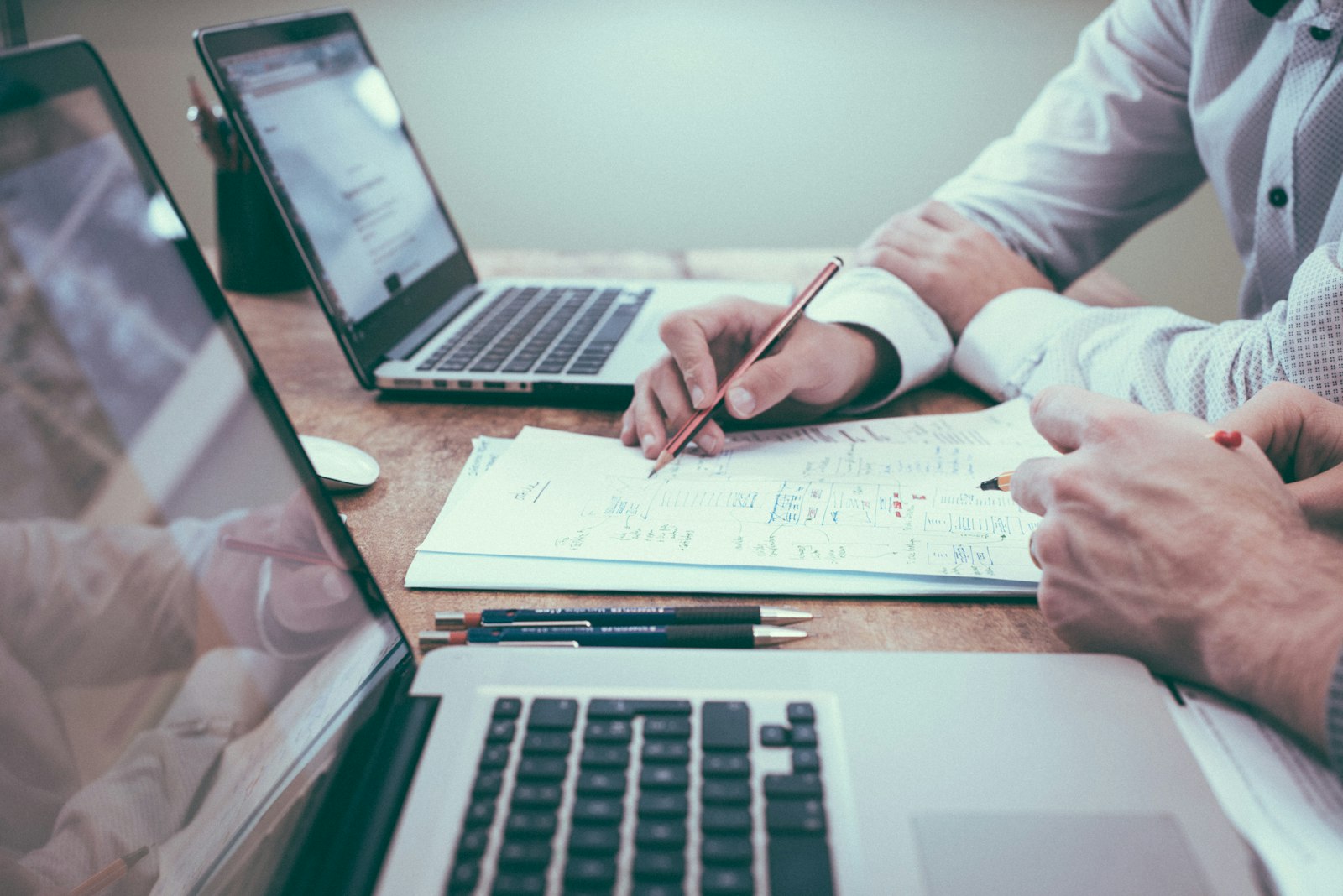 Printed business reports beside a laptop on a desk